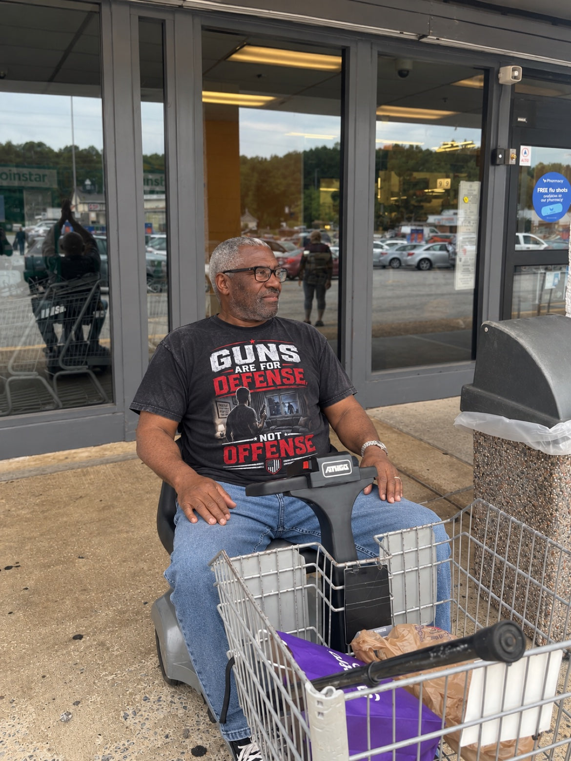 Man wearing the black Guns Are For Defense tee outside a grocery store
