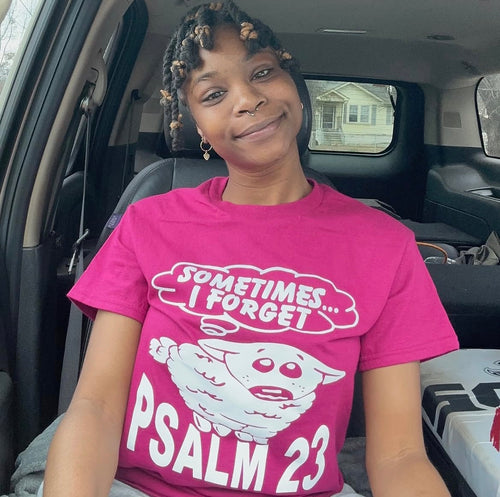 Woman wearing the pink Black Sheep Psalm 23 tee
